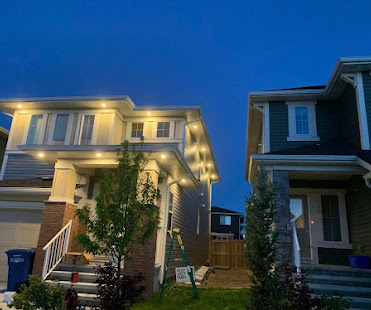 Exterior soffit pot lighting on two-story Calgary homes at night