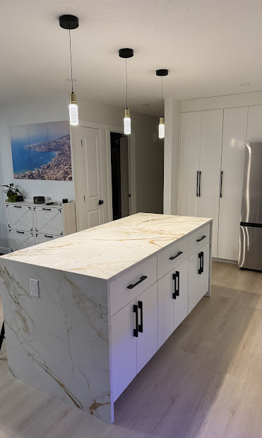 White kitchen renovation with marble island and brass pendants by Nasco Electrical Calgary